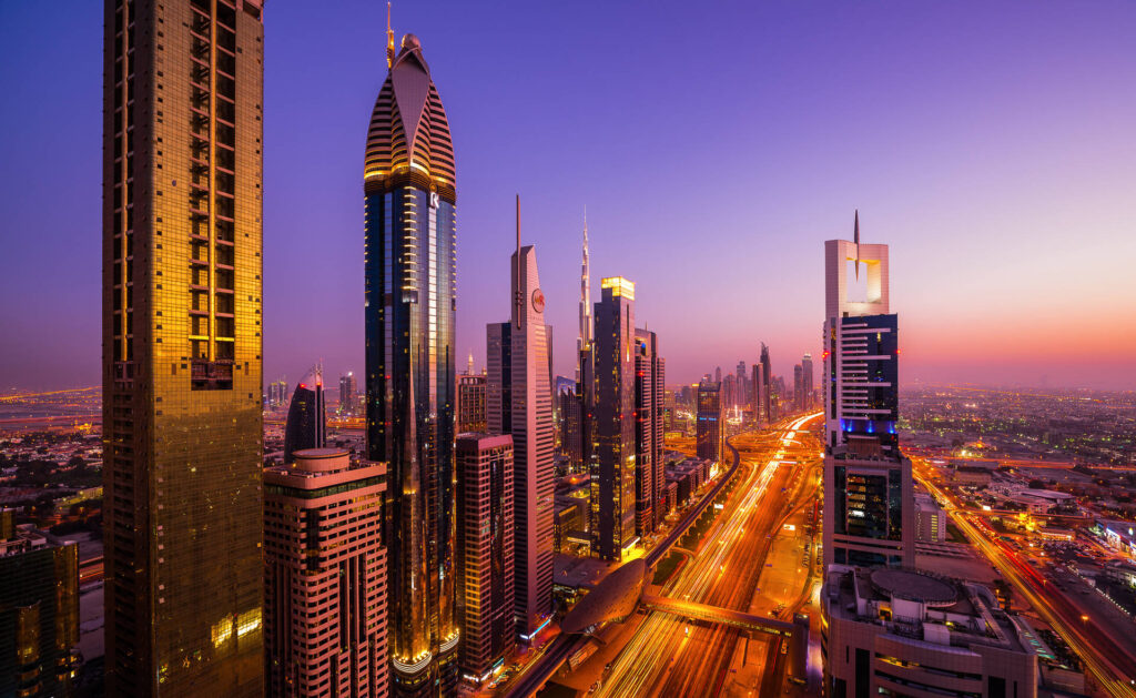 A dynamic long exposure shot of Dubai's Sheikh Zayed Road at night, with streaks of car lights and illuminated skyscrapers creating a mesmerizing cityscape.